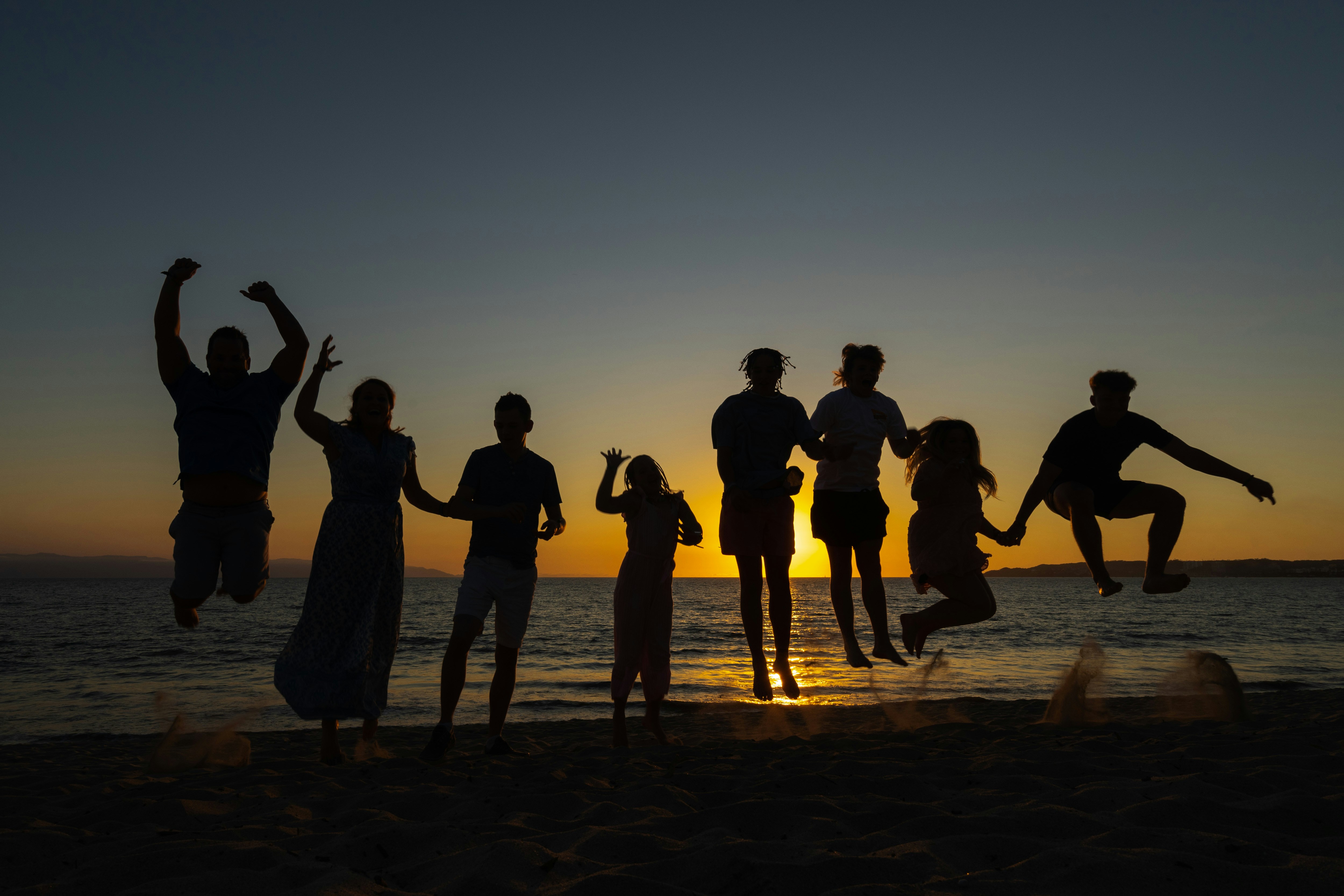 Family photo against a sunset on a beach in Mexico
